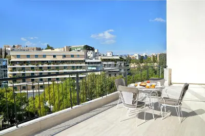 a patio with a table and chairs on a balcony at The Apartment by Athenaeum Hotels in Athens