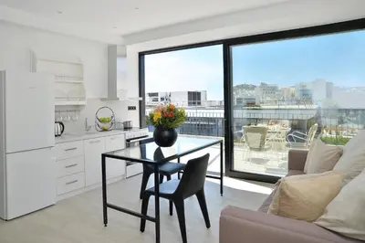 a kitchen with a table with a vase of flowers on it at The Apartment by Athenaeum Hotels in Athens