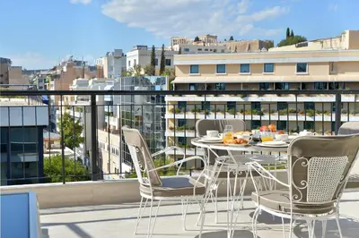 a table and chairs on a balcony with a view at The Apartment by Athenaeum Hotels in Athens