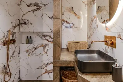 a bathroom with a sink and a marble wall at Delimare, Acropolis & Sea View Rooftop, Paleo Faliro in Athens