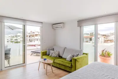 a living room with a green couch and a balcony at Delimare, Acropolis & Sea View Rooftop, Paleo Faliro in Athens