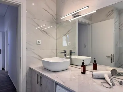 a bathroom with a sink and a large mirror at Pame Rentals - Terrace Dreams with Pasalimani View in Piraeus