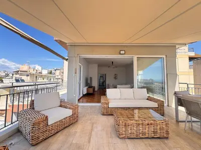 a balcony with two couches and a table and chairs at Pame Rentals - Terrace Dreams with Pasalimani View in Piraeus