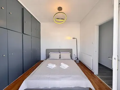 a bedroom with a bed and a yellow light fixture at Pame Rentals - Terrace Dreams with Pasalimani View in Piraeus