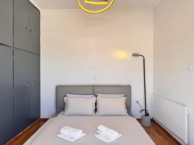 a bedroom with a bed with two towels on it at Pame Rentals - Terrace Dreams with Pasalimani View in Piraeus
