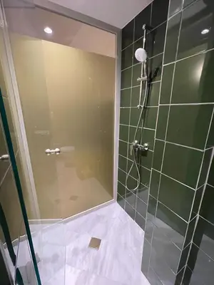 a shower with a glass door in a bathroom at Mooeve Psyri Studios in Athens