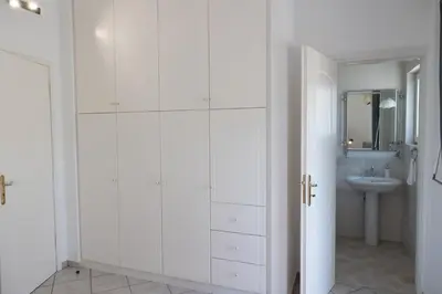 a bathroom with white cabinets and a sink at Aethra Villa in Sounio
