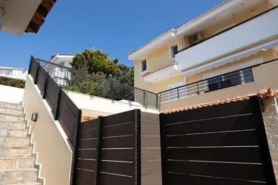 a black fence in front of a house at Aethra Villa in Sounio