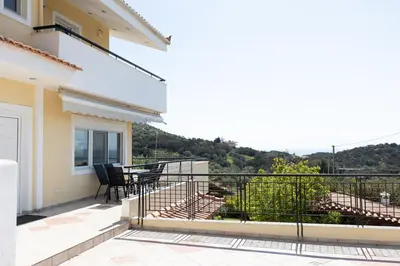 a balcony of a house with a table and chairs at Aethra Villa in Sounio