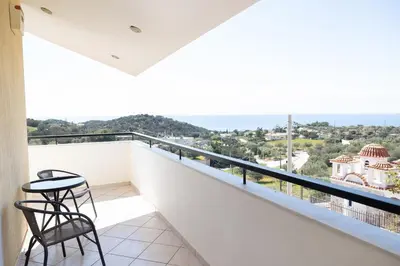 a balcony with a chair and a view of the ocean at Aethra Villa in Sounio