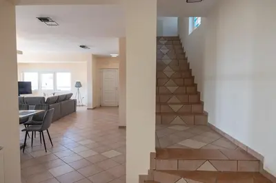 a living room with a staircase and a table at Aethra Villa in Sounio