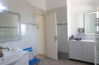 a white bathroom with a sink and a mirror at Aethra Villa in Sounio