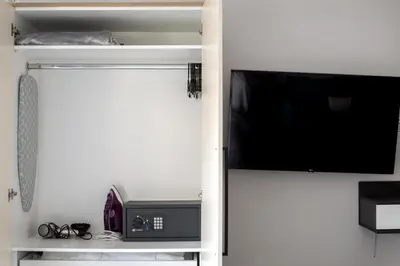a living room with a tv and a book shelf at Orion - Stunning Studio in Athens in Athens