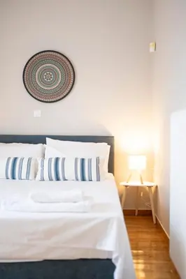 a bedroom with a white bed with a picture on the wall at VK Athens Center in Athens