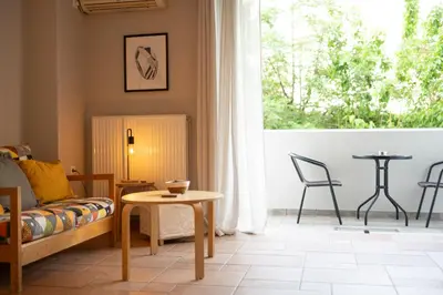 a living room with a couch and a table and a window at VK Athens Center in Athens