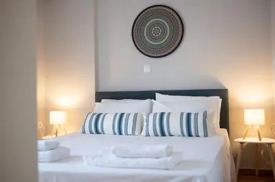 a bedroom with a white bed with two towels on it at VK Athens Center in Athens