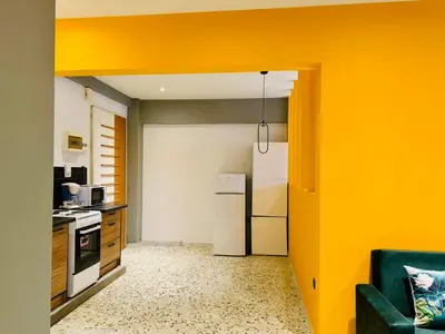 a kitchen with a yellow wall and a refrigerator at Acropolis GrandView in Athens