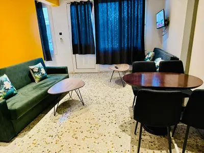 a living room with a couch and a table and chairs at Acropolis GrandView in Athens