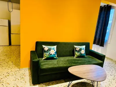 a green couch in a room with a table at Acropolis GrandView in Athens