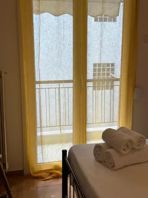 a bedroom with a window with towels on a bed at Timeless Thissio Home in Athens