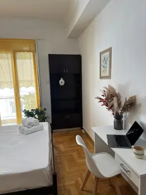 a bedroom with a bed and a desk with a laptop at Timeless Thissio Home in Athens