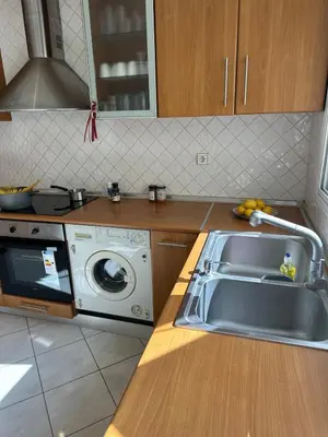 a kitchen with a sink and a washing machine at Timeless Thissio Home in Athens