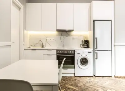 a kitchen with white cabinets and a washer and dryer at Fully Renovated 2bdrm Apartment in Kolonaki area in Athens
