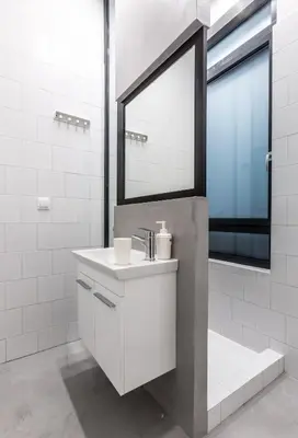 a white bathroom with a sink and a mirror at Fully Renovated 2bdrm Apartment in Kolonaki area in Athens