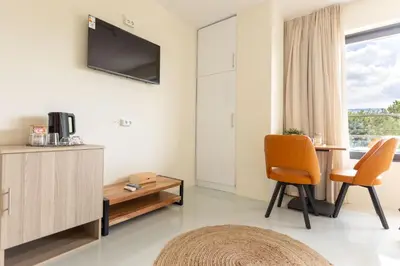 a living room with a tv and a table and chairs at Nobia 8 in Athens