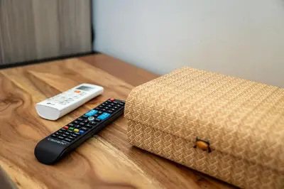 two remote controls and a box on a wooden table at Nobia 8 in Athens