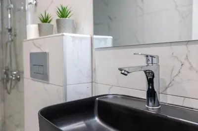 a bathroom sink with a faucet and a mirror at Nobia 8 in Athens