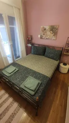 a bedroom with a bed with green sheets and a window at Whole Apartment 52 square meters in the neigboor of Pagrati in Athens in Athens
