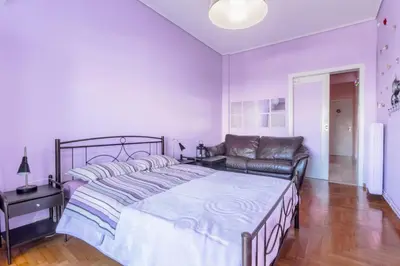 a bedroom with a large bed and a couch at Petaluda House 1 in Athens