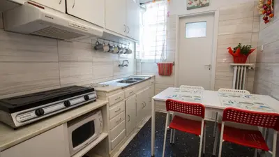 a kitchen with a stove and a counter with red chairs at Petaluda House 1 in Athens