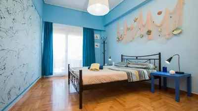 a blue bedroom with a bed and a blue wall at Petaluda House 1 in Athens