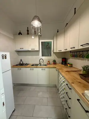 a kitchen with white cabinets and a sink at Petaluda House 1 in Athens