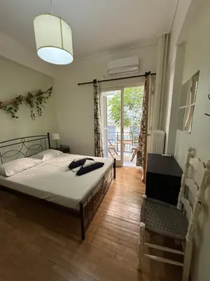 a bedroom with a bed and a sliding glass door at Petaluda House 1 in Athens
