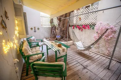 a balcony with a hammock and a table and chairs at Sunny Garden Apartment kolonaki in Athens