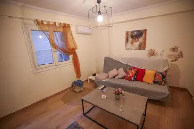 a living room with a couch and a table at Sunny Garden Apartment kolonaki in Athens