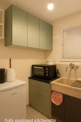 a kitchen with a microwave and a sink at Sunny Garden Apartment kolonaki in Athens