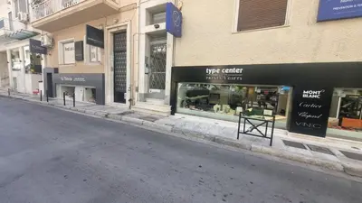 an empty street with a store fronts with windows at Sunny Garden Apartment kolonaki in Athens