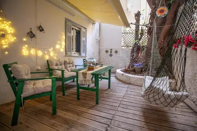 a living room with a green table and chairs at Sunny Garden Apartment kolonaki in Athens