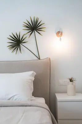 a bedroom with a bed with a plant on the wall at LIV - Trendy Athenian Apartment in Pagrati in Athens