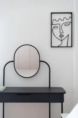 a mirror sitting on top of a black table at LIV - Trendy Athenian Apartment in Pagrati in Athens