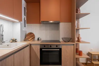 a kitchen with orange cabinets and a stove top oven at LIV - Trendy Athenian Apartment in Pagrati in Athens