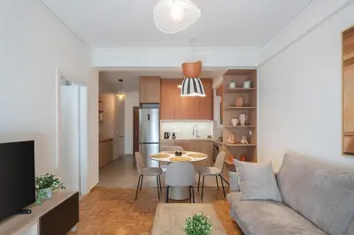 a living room and kitchen with a couch and a table at LIV - Trendy Athenian Apartment in Pagrati in Athens