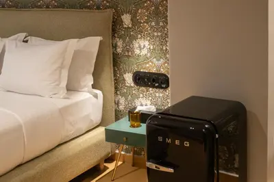 a hotel room with a bed and a side table with a suitcase at Athens Retro in Athens