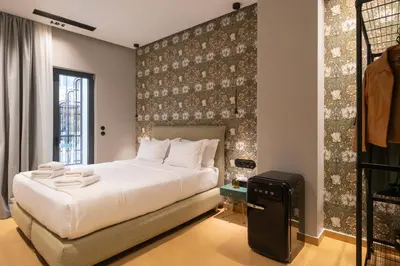 a bedroom with a large white bed and a wall at Athens Retro in Athens