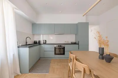 a kitchen and dining room with a table and chairs at Chic & Spacious 3BR Apartment at National Museum by UPSTREET in Athens