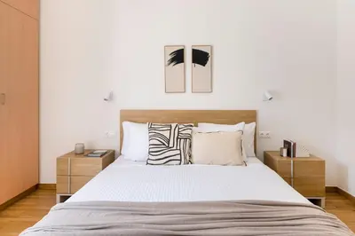 a bedroom with a large bed with white sheets and pillows at Chic & Spacious 3BR Apartment at National Museum by UPSTREET in Athens